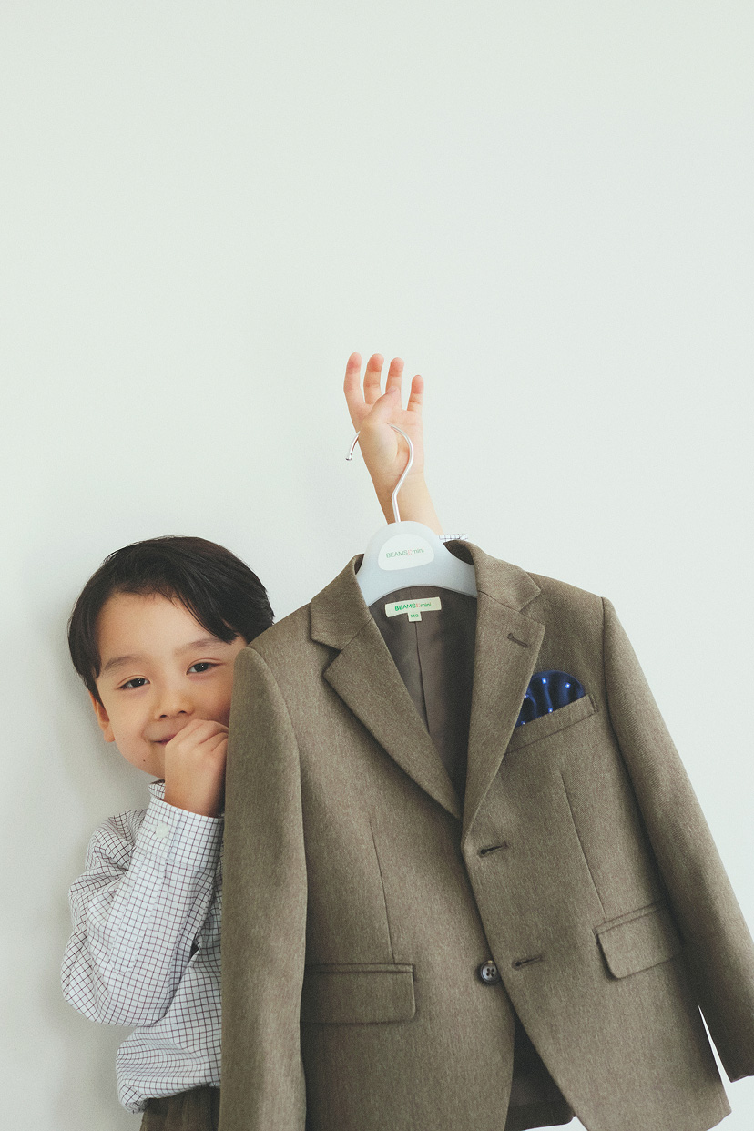 ビームスミニのジャケットがかかったハンガーを持った男の子。スーツ専用のハンガー。