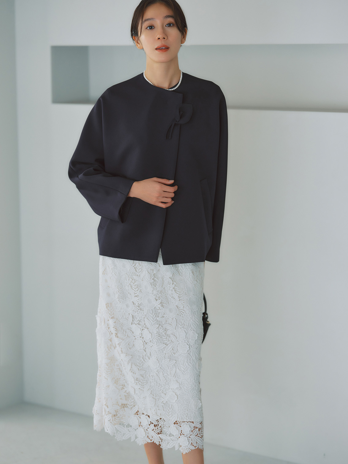 卒園式・入学式におすすめのデミルクス ビームスのネイビーノーカラージャケットと白レースタイトスカートを合わせた上品なフォーマルコーデ